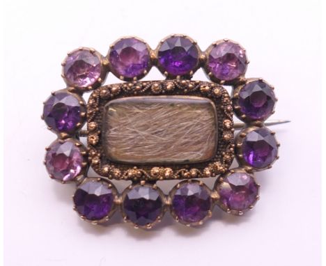 A 19th century unmarked gold amethyst and hair plait mourning brooch. 2.5 cm wide. 