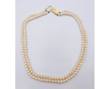 A two strand pearl necklace with 9 ct gold clasp. 33 cm long.