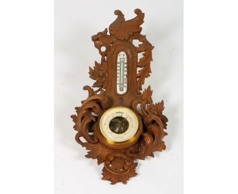   Een houten barometer, 20e eeuw. Met houtsnijwerk van rocailles, B: 28 cm, H: 61 cm. Geschatte opbrengst: € 10 - € 20.      