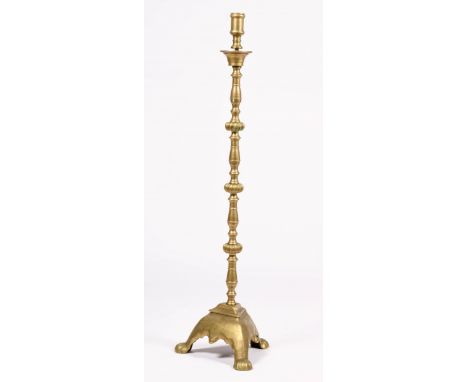   Een koperen kandelaar, laat 19e eeuw. Met kaarsenhouder, geknoopte steel en op driepoot, H: 112 cm. Geschatte opbrengst: € 