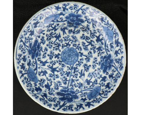  Een Porseleinen schotel met floraal decor gemerkt aan achterzijde met artimisia blad. China,Kangxi. Diam. 35 cm. Randschade