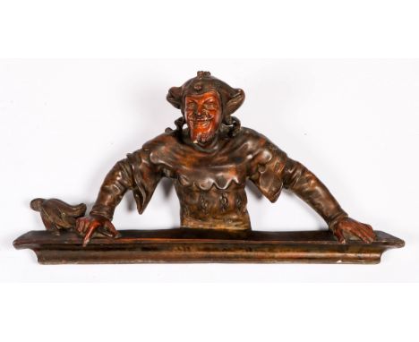   Een gestoken ornament in de vorm van een nar, 20e eeuw. L: 21 cm, B: 70 cm, H: 36 cm. Geschatte opbrengst: € 30 - € 50.    