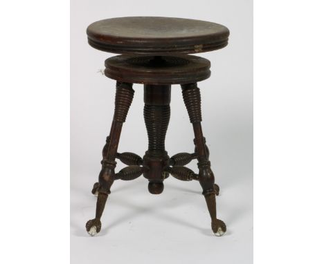   Een notenhouten pianokruk, ca. 1890. Op klauw-en-bol poten (de bol van glas, een ontbrekend), H: 49 cm, Diam: 43 cm.       