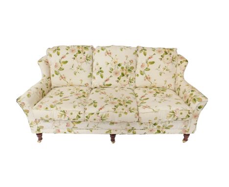 A Hallmark Designs three seater Alison sofa, upholstered in a rose and floral patterned fabric against a cream ground, raised