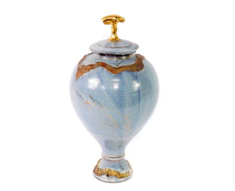 A studio pottery vase and cover, of baluster form, gilt decorated with fish and moulded with seaweed, against a powder blue g