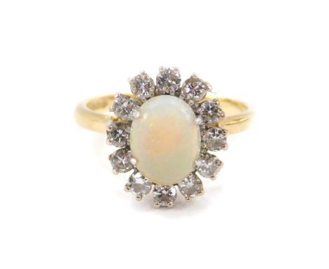 An 18ct gold opal and diamond ring, the opal set in a surround of twelve brilliant cut diamonds, approx 0.75cts, size P, 5.0g