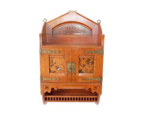 A Victorian Aesthetic period oak wall cabinet, c1880s, the three sided shelf top painted to the back with a sunburst motif, a