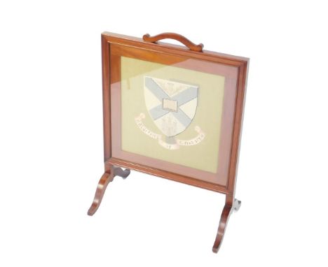 A Victorian mahogany and tapestry fire screen, decorated with a Coat of Arms and motto, raised on four cabriole legs, 91cm H,