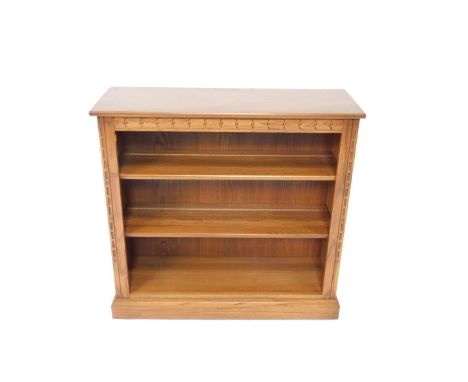 An Ercol oak open bookcase, with two shelves raised on a plinth base, 92.5cm H, 96cm W, 34cm D.