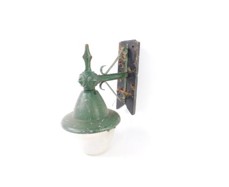 A green painted metal wall hanging street lamp, circa 1920s, with a plastic bucket shade, wooden mounted, 48cm H, 39cm W.