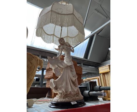A decorative table lamp in the form of a lady. 