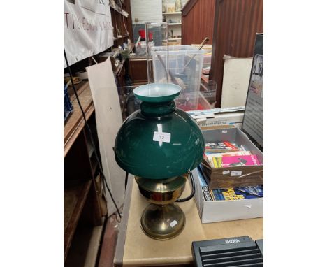 A brass oil lamp with green glass and clear funnel 