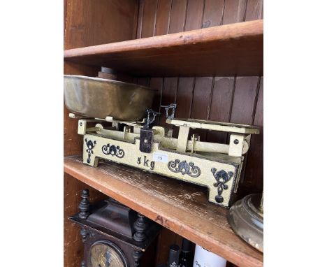 A vintage cast metal 5kg balance scale with brass tray and weights. 
