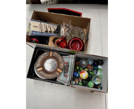 A box of Las Vegas souvenirs including a 1950s roulette wheel ashtray, a box of vintage marbles and bollies and a box of mixe