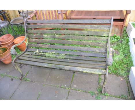 A WOODEN SLATTED GARDEN BENCH with lion mask cast iron ends 131cm wide (Condition very weathered and slightly rickety)