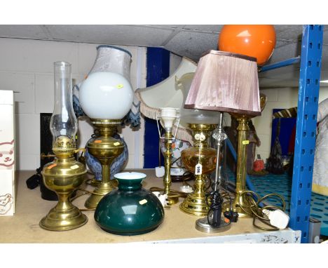 EIGHT TABLE LAMPS, SHADES AND CHIMNEYS, comprising a brass based oil lamp, three electric lamps in the form of oil lamps, cer