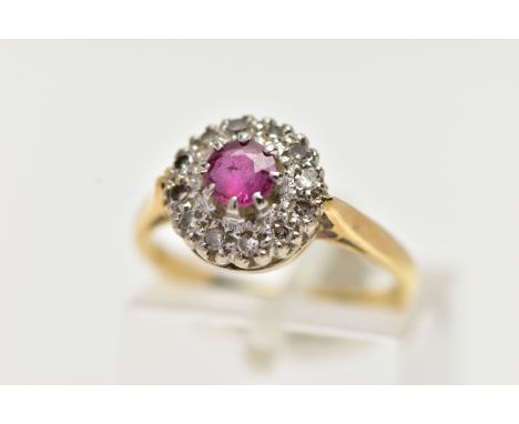 AN 18CT GOLD RUBY AND DIAMOND CLUSTER RING, centering on a circular cut ruby, in an eight claw setting, within a surround of 