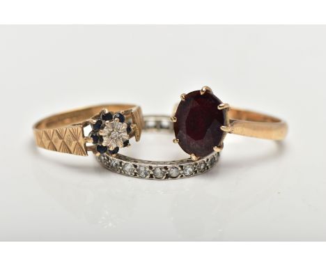 THREE GEM SET RINGS, the first designed with an oval cut garnet in an eight claw setting with openwork gallery, pinched shoul