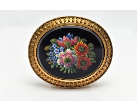 A VICTORIAN MICRO MOSAIC BROOCH, of an oval form, centering on an onyx oval inlay decorated with a floral micro mosaic patter