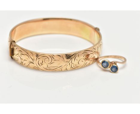 A 9CT GOLD SAPPHIRE RING AND A GOLD PLATED HINGED BANGLE, the ring of a cross over design, set with two circular cut light bl