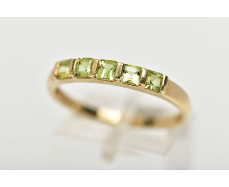 A 9CT GOLD PERIDOT RING, designed with a row of five bar set, square cut peridots, to a polished band, hallmarked 9ct Birming