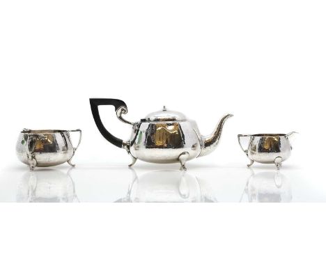 A silver three piece tea service by Barker Brothers, Chester 1906, with planished decoration, comprising a teapot, 26cm wide,