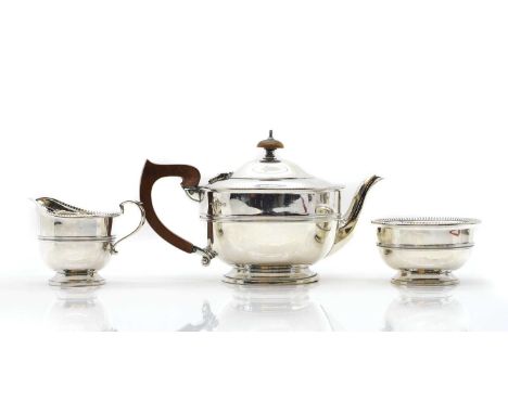 A silver tea service, comprising a teapot by Oldfield Ltd, Birmingham 1931, with beaded decoration, 25cm widea cream jug, 8cm