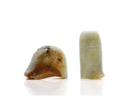 Two Chinese jade cups, 20th century, of archaic form, one carved with taotie masks, the other with a dragon, 9.6 and 10.5cm l