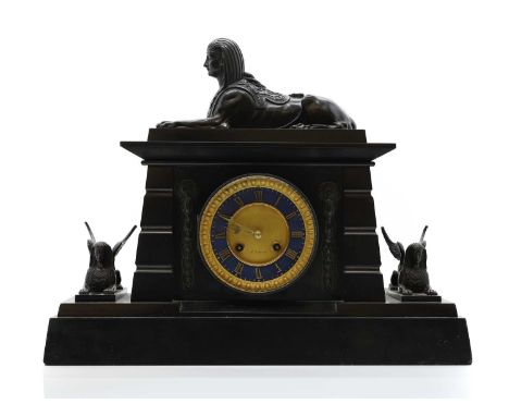 A Victorian Egyptian Revival black slate mantel clock mounted by a Spinx, to a gilt metal and blue painted dial with Roman nu