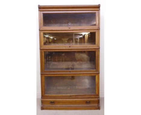 A 1930s Globe Wernicke oak five section bookcase, having four rise-and-slide glazed panelled doors and a base drawer  60''h  