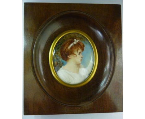 A 20thC head and shoulders portrait miniature, a girl wearing a ribbon in her auburn hair  bears an indistinct signature, in 