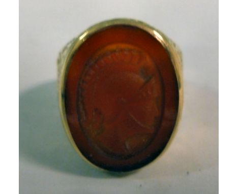 A 9ct gold signet ring, having cast foliate scrolled ornament, the oval, amber coloured seal carved with the profile portrait