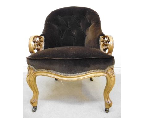 A late Victorian satin mahogany framed armchair with foliate carved and pierced decoration, part button upholstered in a brow