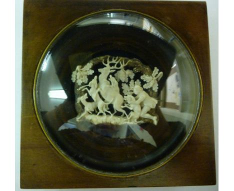 An early 20thC Continental finely carved, (possibly ivory) stag hunting scene, set in a convex glazed mahogany box frame  4.5