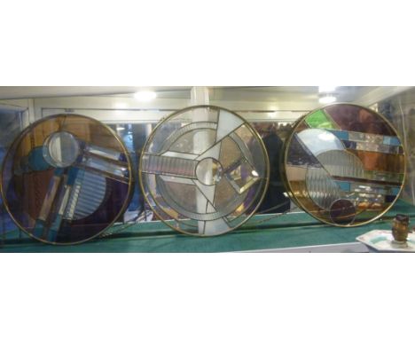 A set of three Art Deco inspired cut and plain, semi-opaque and clear lead glazed pendant discs in brass frames, interconnect