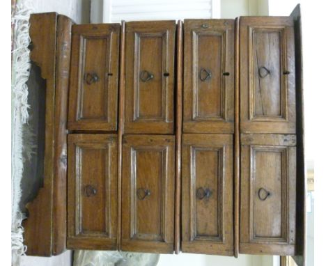 An early 18thC and later oak dressing chest, having eight short, recessed panelled drawers with iron ring handles, raised on 