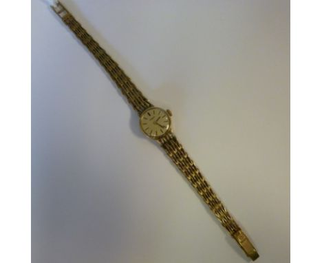 A lady's Tissot 9ct gold round cased wristwatch, faced by a baton dial, on a textured, tapered arrow-link bracelet