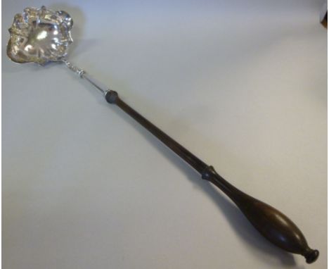 A Georgian silver toddy ladle, having an oval, lobed bowl, on a turned mahogany handle  London marks rubbed