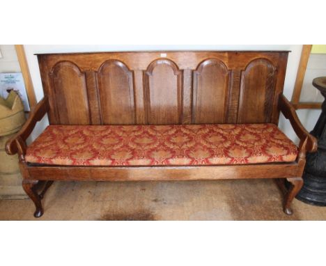 A long oak hall bench or settle, arched back, leather seated with later cushion