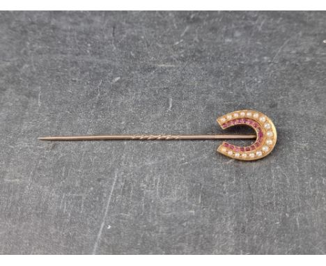 A 19th century yellow metal stick pin, with horse shoe terminal, set seventeen graduated split pearls and seventeen faceted r