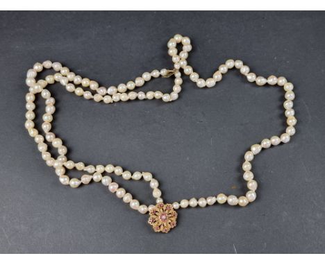 A baroque cultured pearl choker, having ruby and pearl set clasp stamped '9c', 39cm long. 