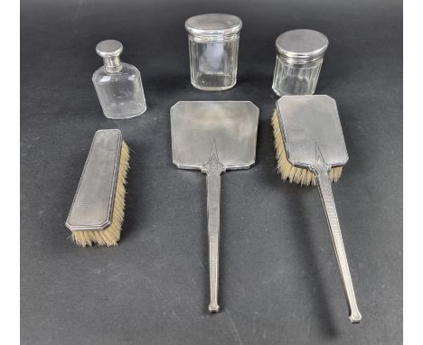 An Art Deco engine turned silver three piece dressing table set,&nbsp;by two different makers; together with three similar si