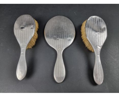 An engine turned silver mounted three piece dressing table set,&nbsp;by&nbsp;Synyer &amp; Beddoes, Birmingham 1910/11. 