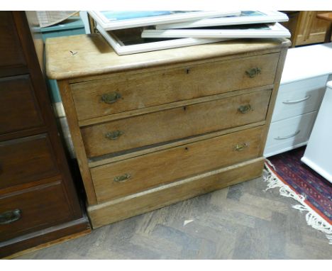 A 3'3 low light oak chest of 3 long drawers 