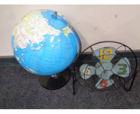 A globe on stand together with a battery operated clock in the form of a vintage fan  