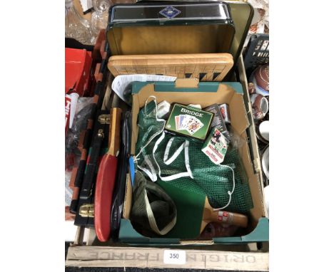 A box containing playing cards, cased backgammon, table tennis bats etc 