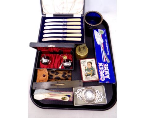 A tray containing cased silver plated butter knives, vintage spirit level, brass bell, Snap Little Jack Horner cards  