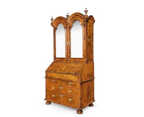 A QUEEN ANNE FIGURED WALNUT AND FEATHER BANDED BUREAU CABINET CIRCA 1710 The mirror panel doors opening to an arrangement of 
