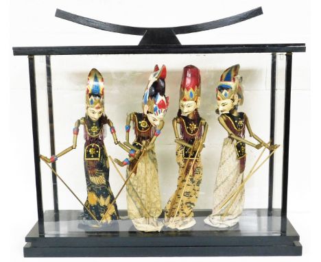 An Eastern glass display case with four puppet figures, each in floral dress with sequin bordering, 72cm high, 93cm wide, 29c