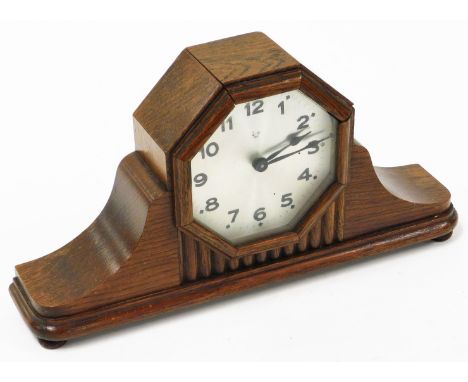 An Art Deco mantel clock, in an oak case with silvered coloured dial, on bun feet, 33cm wide, 18cm high.
